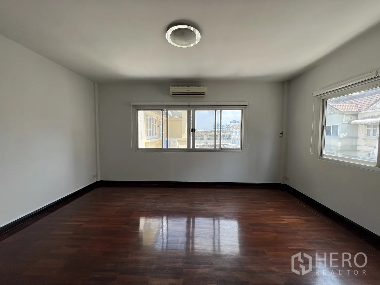 ทาวน์เฮาส์ ให้เช่าในKhlong Toei, Bangkok - ห้องนอนมุมบ้านมีหน้าต่างสามด้าน เห็นวิวเมือง พร้อมพื้นไม้และแอร์