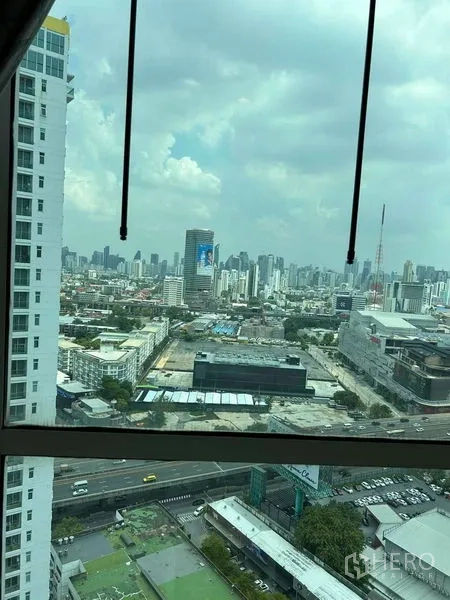 Condominium for sale in Huai Khwang, Bangkok - High-floor window view across Bangkok skyline and main roads.