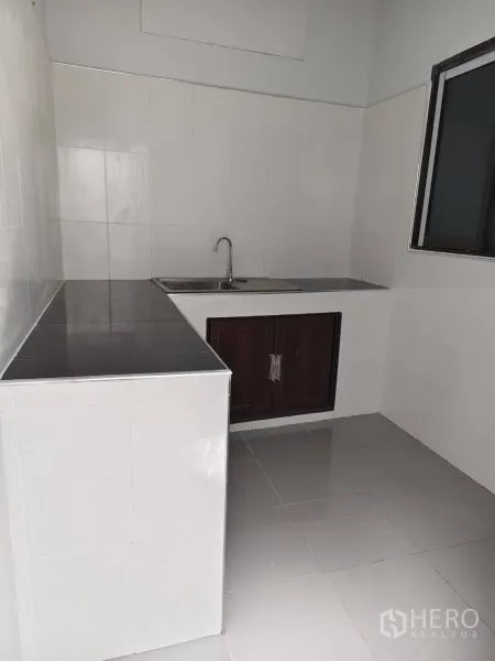 ทาวน์เฮาส์ ขายในPhra Khanong, Bangkok - ครัวไทยเรียบง่าย เคาน์เตอร์ปูกระเบื้อง อ่างล้างจาน และหน้าต่างระบายอากาศ