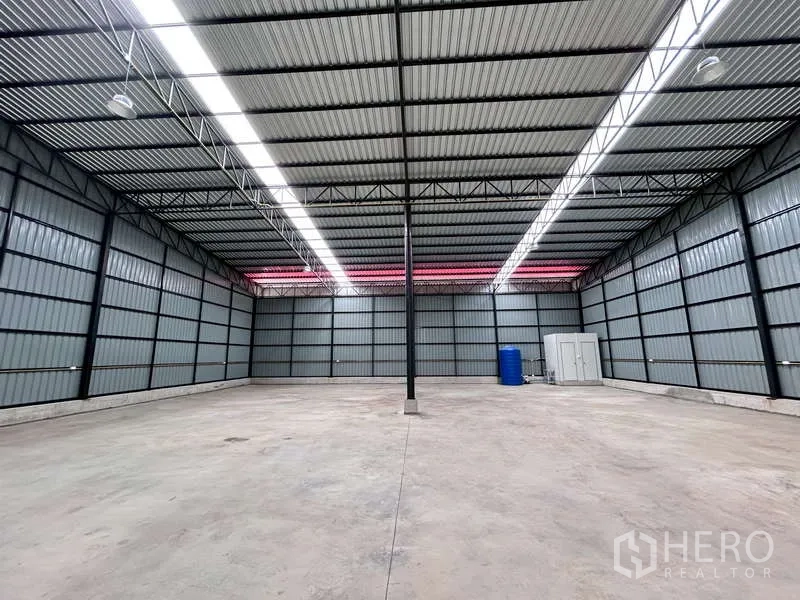 Warehouse for rent in Mueang Chachoengsao, Chachoengsao - Spacious warehouse interior with high steel roof, skylight strips, and polished concrete floor.