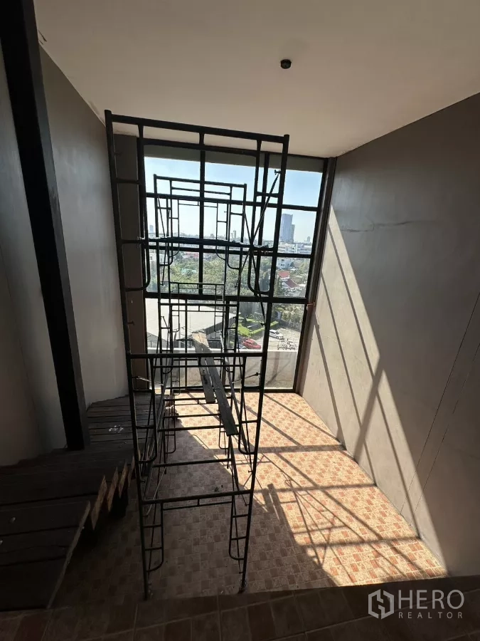 店屋 出租在Bang Na, Bangkok - 自狭窄楼梯向下望向高窗与城市景观。