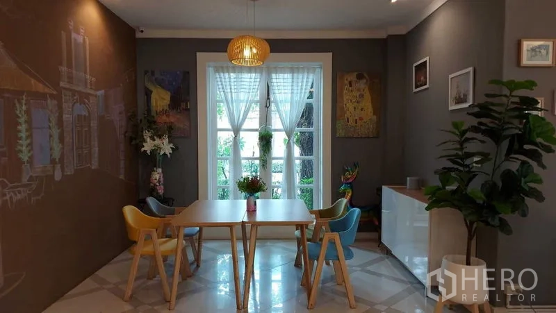 零售空间 出租在Bueng Kum, Bangkok - 温馨座位区，艺术墙面、吊灯与装饰画