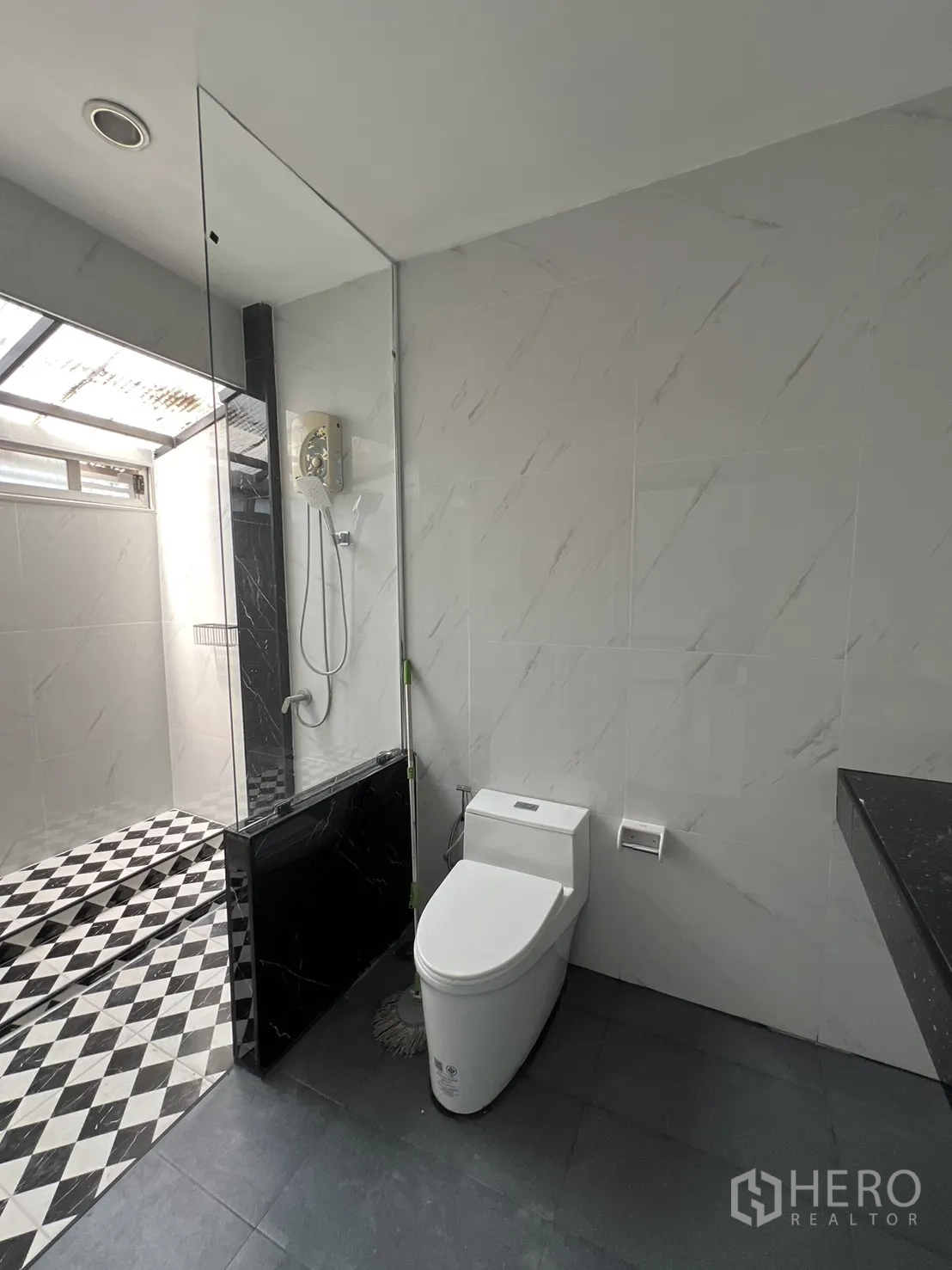 ทาวน์เฮาส์ for rent in Watthana, Bangkok - ห้องน้ำสว่าง มีโถสุขภัณฑ์และพื้นที่อาบน้ำยกสเต็ป กระเบื้องลายตารางขาวดำ