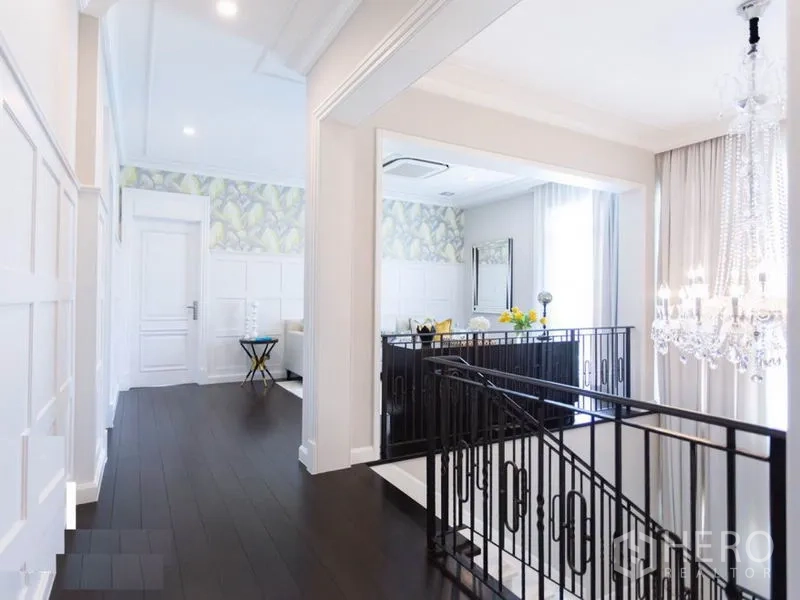 บ้าน ให้เช่าในMueang Samut Prakan, Samut Prakan - โถงชั้นบนพื้นไม้เข้ม โคมไฟคริสตัล และราวบันไดเหล็กดัด