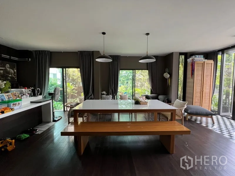 Detached House for sale in Bang Kapi, Bangkok - Spacious open dining room with dark wood floors and sliding doors to the garden.