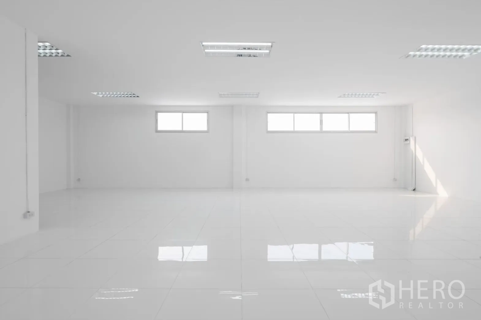 โรงงาน ให้เช่าในPathum Thani - พื้นที่ทำงานสีขาวเปิดโล่ง มีหน้าต่างแนวนอนสามบานและพื้นมันเงา