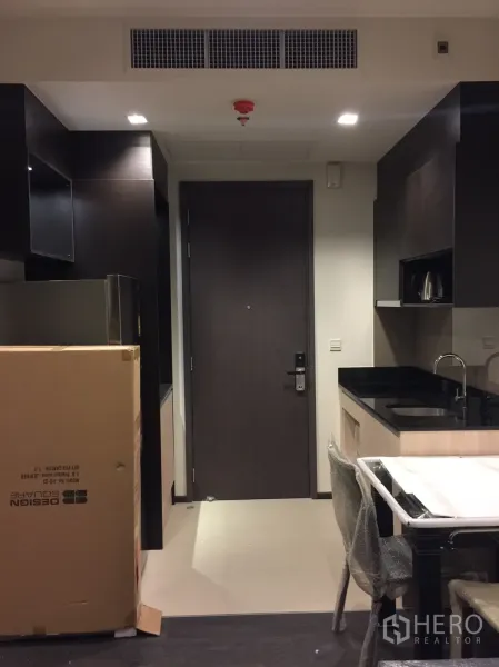 公寓 出租在Watthana, Bangkok - 开放式厨房，黑色台面与嵌入式橱柜，设用餐角。