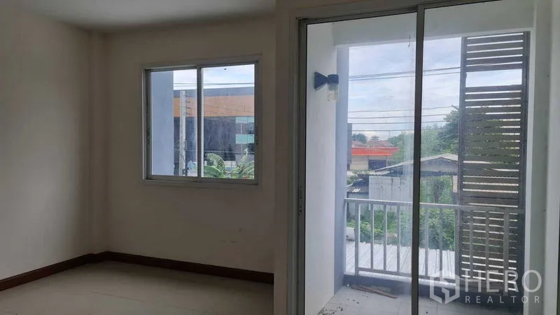 联排别墅 for 在Lam Luk Ka, Pathum Thani - 卧室带窗户与推拉玻璃门，通往小阳台，社区景观。