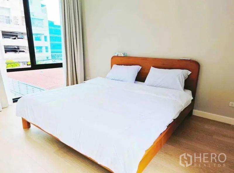 Detached House for rent - Guest bedroom with a wooden bed frame and city-view window.