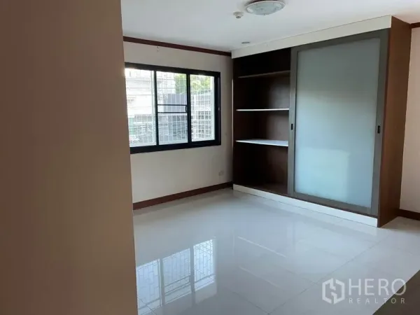 Office Space for rent in Khlong Toei, Bangkok - Bright empty office room with large window, built-in shelving and frosted sliding-door cabinet