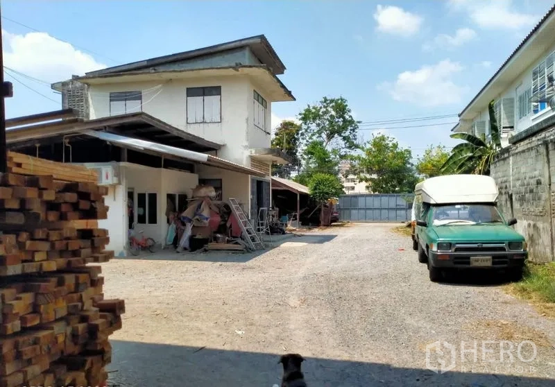 Warehouse for sale in Mueang Nonthaburi, Nonthaburi - Spacious yard with a two-storey office building, gravel driveway and sliding gate.