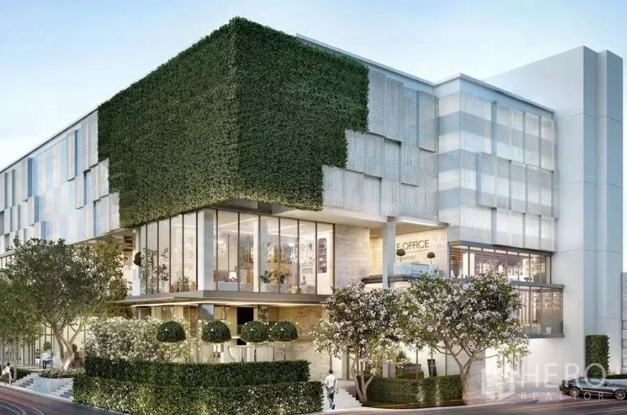 独立商业地产 出售在Watthana, Bangkok - 转角视角的当代建筑，绿化体量与通高玻璃。