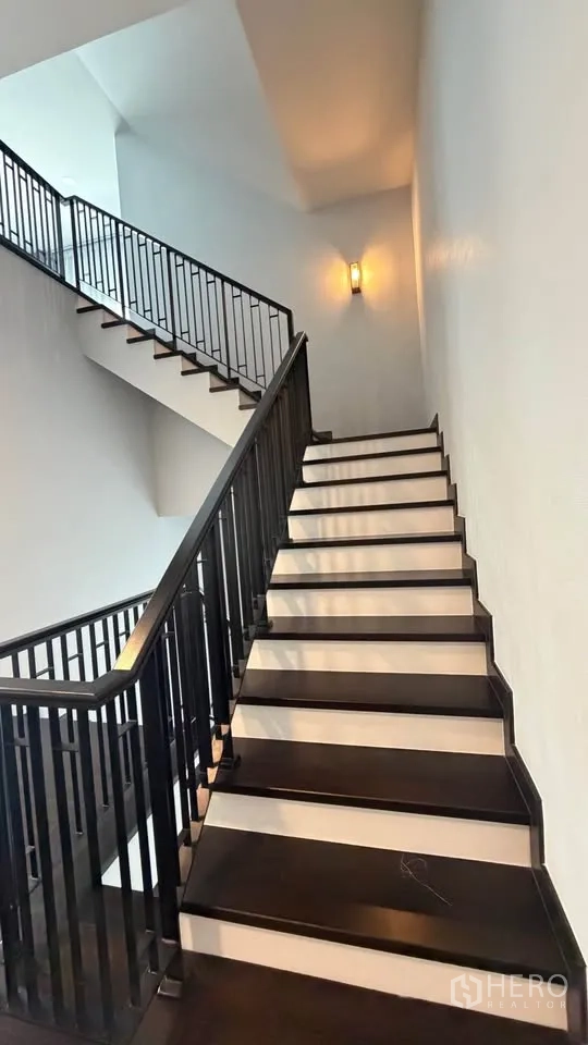 Detached House for rent in Bang Phli, Samut Prakan - Wide staircase with dark wood treads and black metal railing.