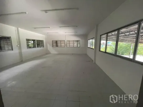 Factory for rent in Sam Khok, Pathum Thani - Bright office room with tiled floor, fluorescent lighting and many windows.
