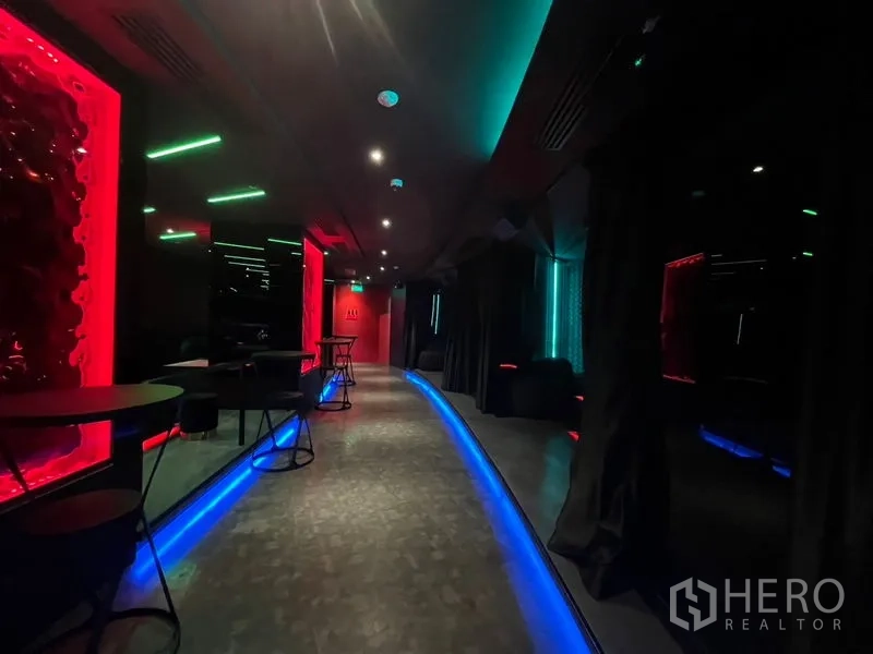 零售空间 出租在Ratchathewi, Bangkok - 宽走廊，蓝色地脚灯，墙边摆放小圆桌。