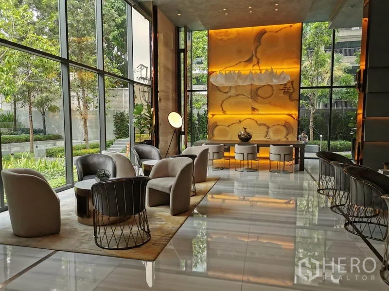 Condominium for rent in Watthana, Bangkok - Elegant double-height lobby lounge with garden views, modern seating, and warm lighting.