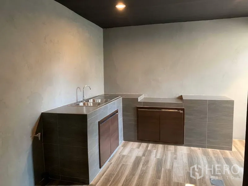 联排别墅 出租在Bang Kapi, Bangkok - 极简泰式厨房，瓷砖台面、双槽水槽与木纹地面。