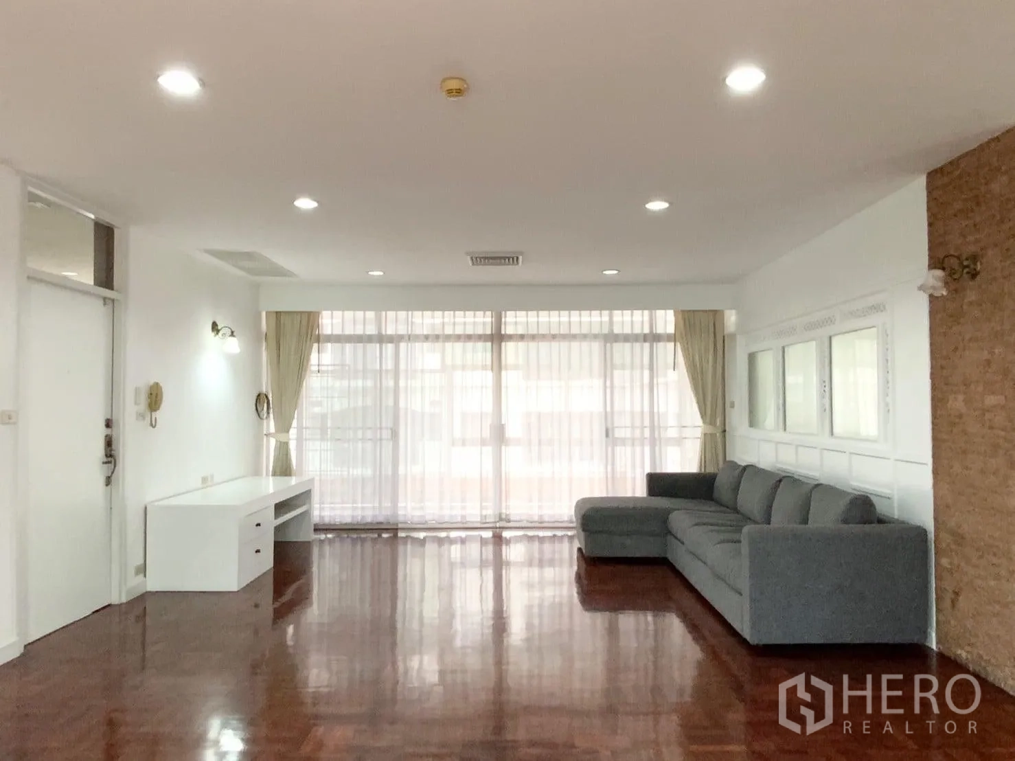 คอนโด ให้เช่าในWatthana, Bangkok - ห้องนั่งเล่นกว้างมีประตูกระจกบานเลื่อนสู่ระเบียงและโซฟาแอล