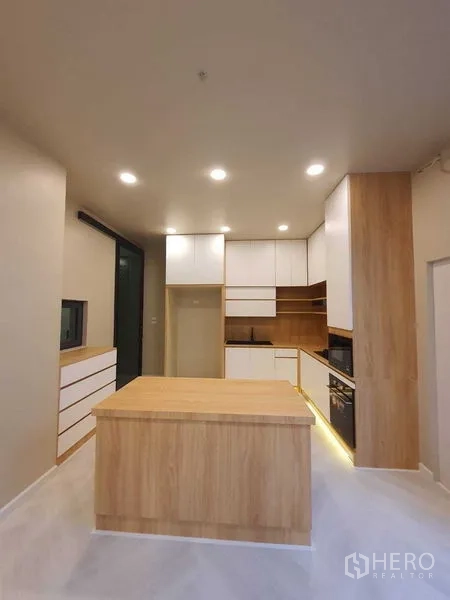 Detached House for sale in Prawet, Bangkok - Contemporary kitchen with wood island and plentiful cabinets.