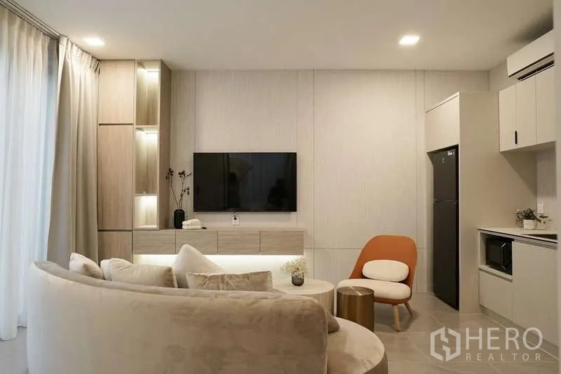 Detached House for rent in Saphan Sung, Bangkok - Secondary living room with TV wall, compact pantry and curved sofa seating.