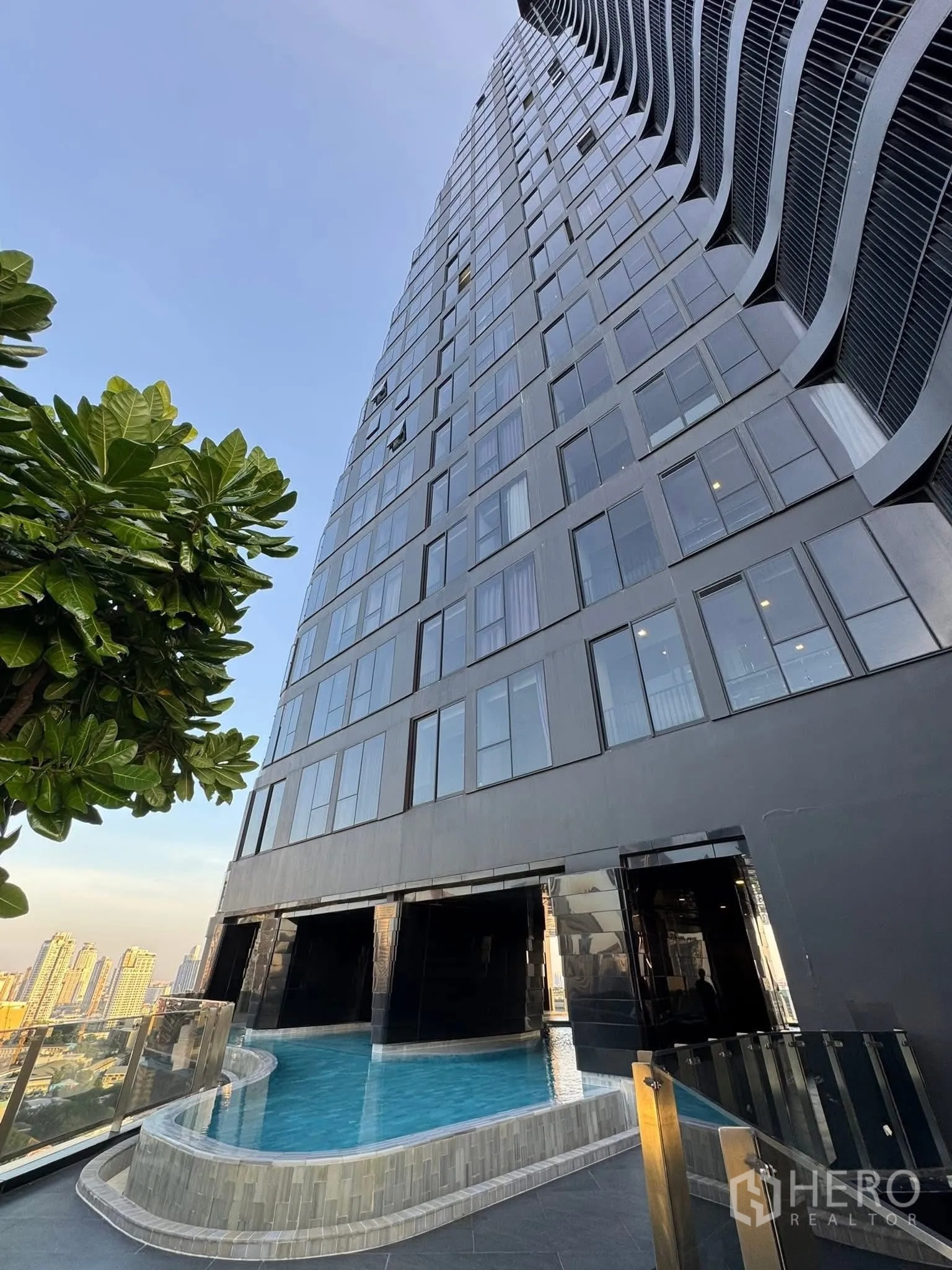 คอนโด for rent in Khlong Toei, Bangkok - ภายนอกคอนโดไฮไรส์สมัยใหม่ หน้าตาโค้ง พร้อมดาดฟ้าสระว่ายน้ำ