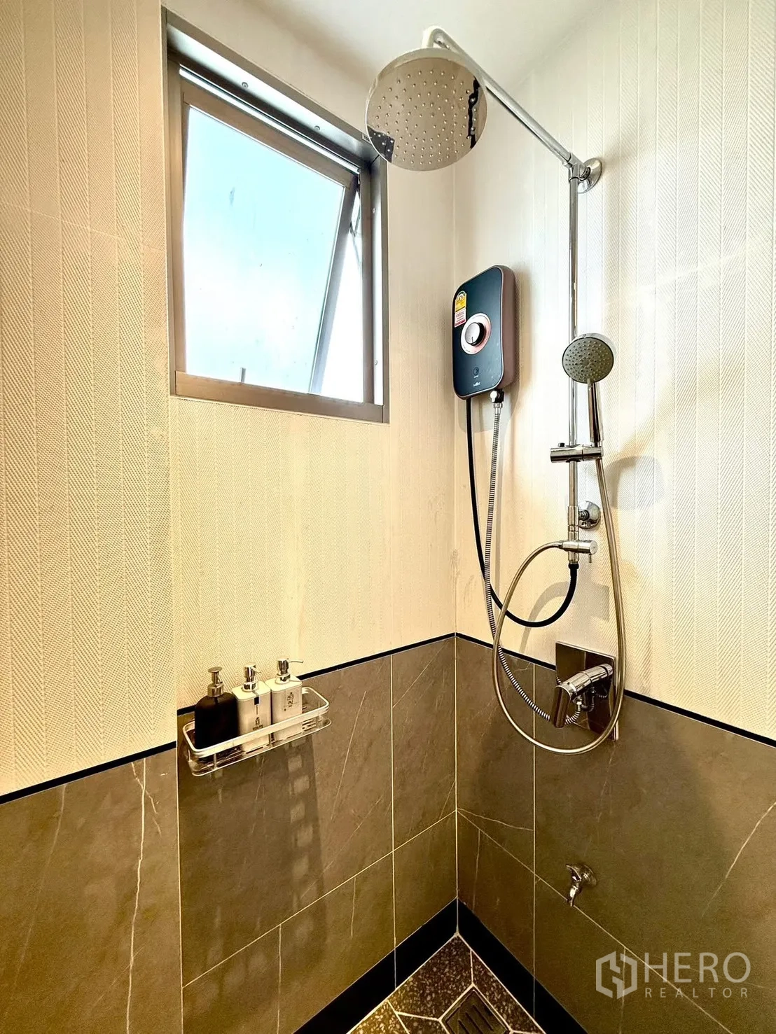 Detached House for rent or sale in Bang Phli, Samut Prakan - Bathroom corner with window, rain shower and water heater against tiled walls.