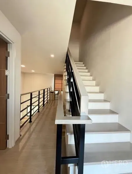 联排别墅 出租在Bang Phli, Samut Prakan - 黑色金属扶手楼梯通往夹层走廊。