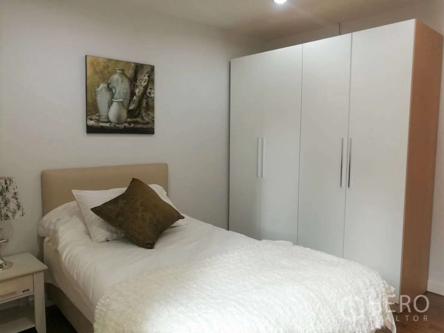 Condominium for rent in Watthana, Bangkok - Second bedroom with single bed, white wardrobe and soft neutral décor.