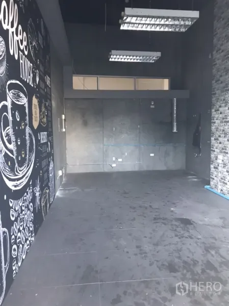零售空间 出租在Khlong Toei, Bangkok - 32平方米空置商铺，深色地砖、清水泥墙、高吊灯及咖啡主题黑板墙。