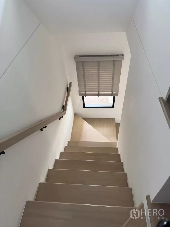 Townhouse for rent in Bang Phli, Samut Prakan - Wooden staircase with handrail and window bringing natural light.