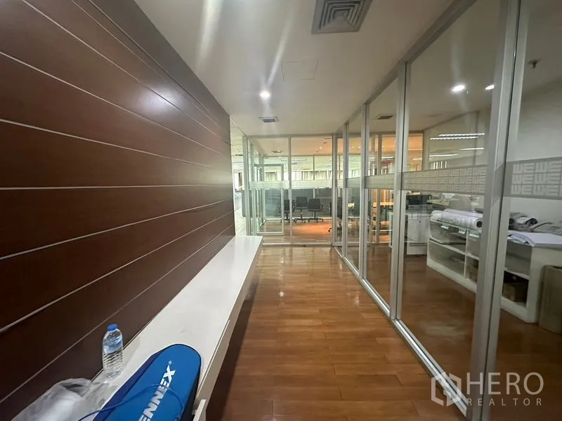 Office Space for rent - Hallway with wood panel feature wall and glass-partitioned offices
