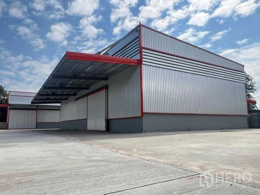 货栈 出租在Khlong Sam Wa, Bangkok - 新建金属外墙仓库转角视图，深雨棚与宽阔硬地。