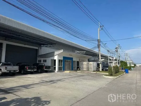 Factory for rent in Bang Sao Thong, Samut Prakan - Row of industrial units with wide internal road, power lines and outdoor parking bays.