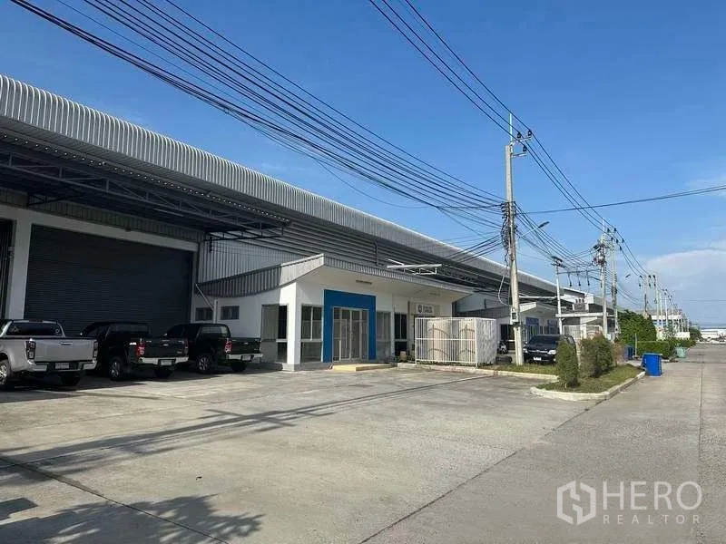 Factory for rent in Bang Sao Thong, Samut Prakan - Row of industrial units with wide internal road, power lines and outdoor parking bays.