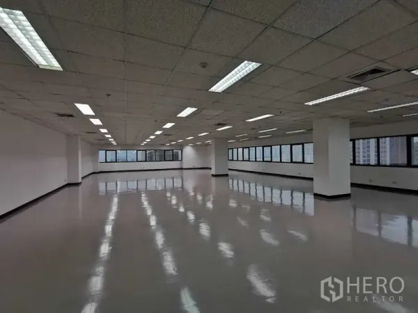 办公空间 出租在Watthana, Bangkok - 带立柱的开放办公区，条形照明与全景窗，眺望曼谷。