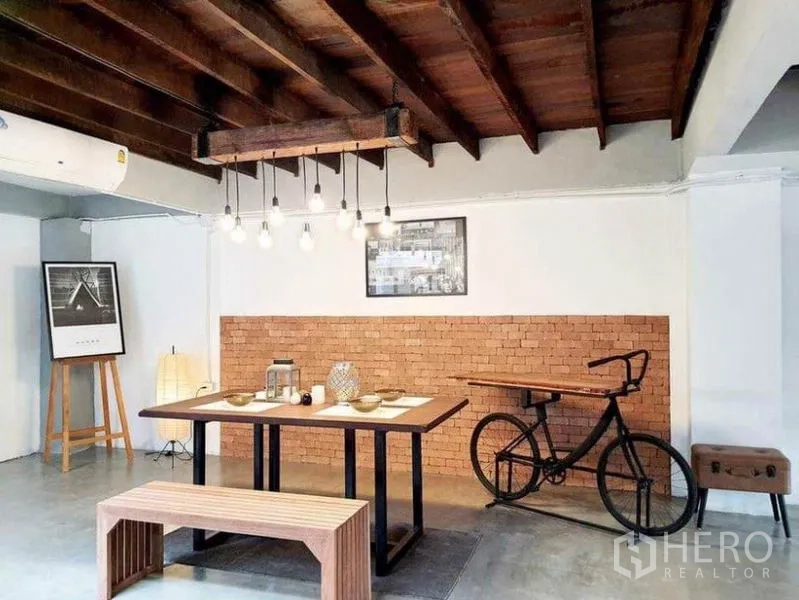 Detached House for rent in Pathum Wan, Bangkok - Industrial dining area with pendant bulbs, brick feature wall and wooden ceiling beams