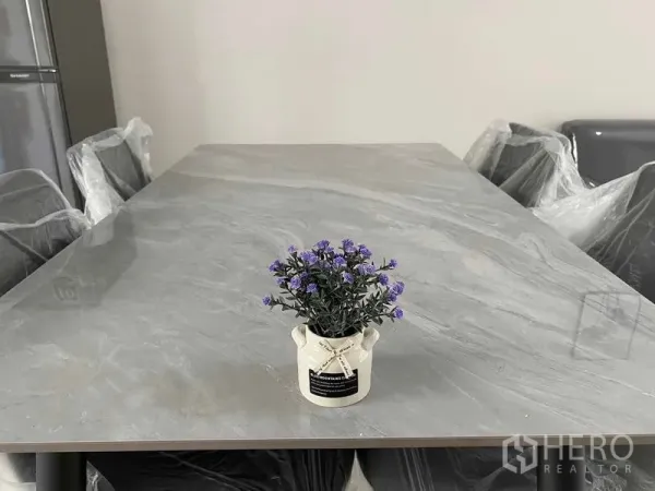 联排别墅 出租在Prawet, Bangkok - 餐桌特写，石纹台面，中间摆放小型盆栽。