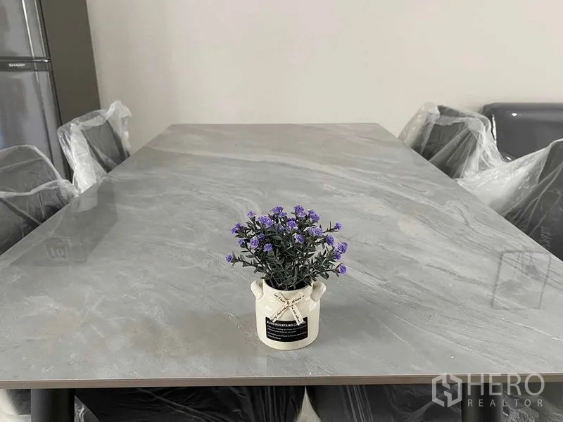 联排别墅 出租在Prawet, Bangkok - 餐桌特写，石纹台面，中间摆放小型盆栽。