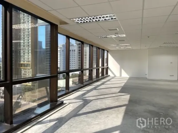 สำนักงาน ให้เช่าในRatchathewi, Bangkok - แถวกระจกยาวทอดเงาบนพื้นคอนกรีต พื้นที่สำนักงานโล่งพร้อมวิวเมือง