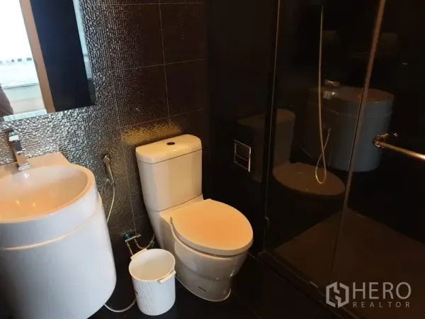 คอนโด ให้เช่าในKhlong Toei, Bangkok - ห้องน้ำโทนเข้มสไตล์โมเดิร์น กั้นอาบน้ำกระจก อ่างล้างหน้าแบบทรงกลม และโถสุขภัณฑ์