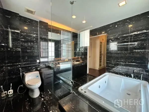Detached House for rent or sale - Luxury bathroom with black marble walls, glass shower enclosure and jacuzzi bathtub.