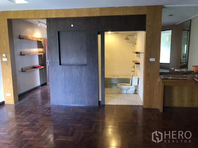 Townhouse for rent or sale in Watthana, Bangkok - Master suite corridor with open shelving and a sliding door leading to the bathroom.