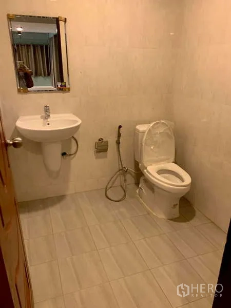 独立式住宅 出租或出售在Phra Khanong, Bangkok - 整洁浴室，挂墙式洗手盆、马桶与喷枪。