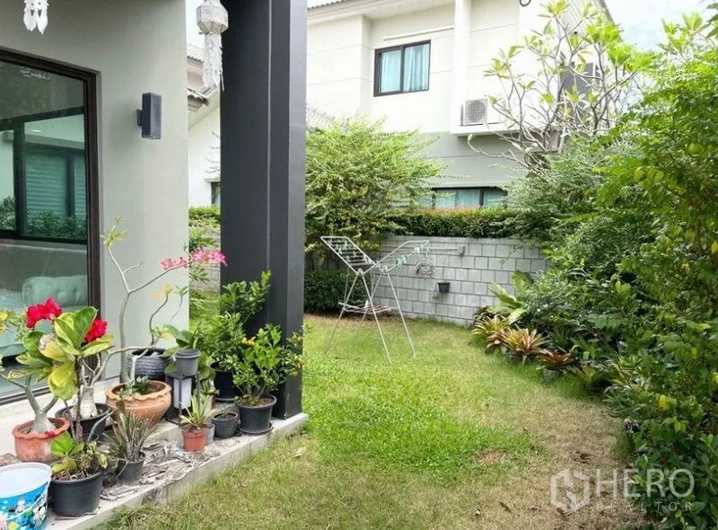 Detached House for rent - Private corner garden with lawn, potted plants, and patio beside the house.