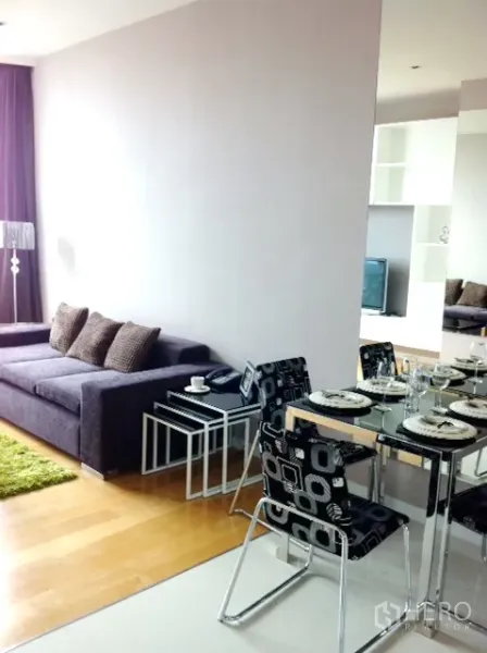 คอนโด ให้เช่าในWatthana, Bangkok - มุมทานอาหารโต๊ะกระจก เก้าอี้ลายกราฟิก ข้างโซฟานั่งเล่นโทนม่วง