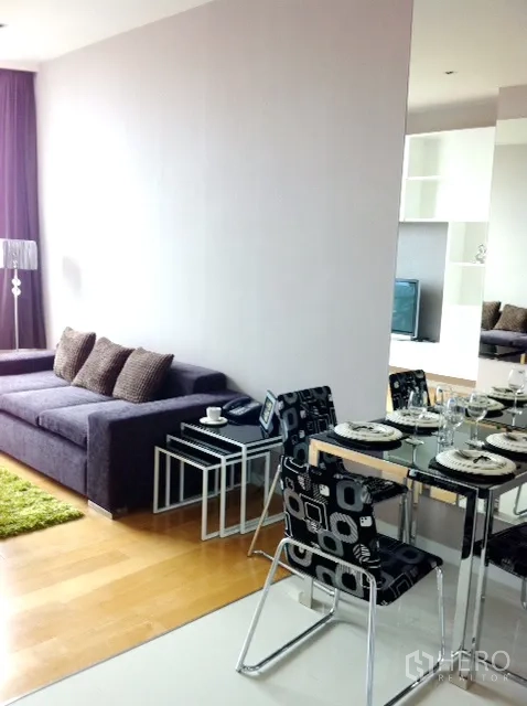 คอนโด ให้เช่าในWatthana, Bangkok - มุมทานอาหารโต๊ะกระจก เก้าอี้ลายกราฟิก ข้างโซฟานั่งเล่นโทนม่วง