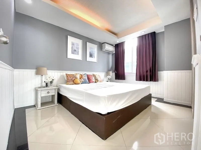 คอนโด ให้เช่าในKhlong Toei, Bangkok - ห้องนอนหลักเพดานฝ้าหลุม มีโต๊ะข้างเตียง แอร์ และผ้าม่าน