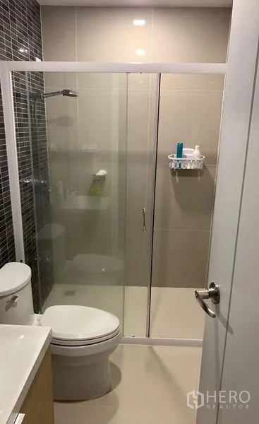 联排别墅 出租在Thanyaburi, Pathum Thani - 整洁浴室，墙面瓷砖、马桶、洗手台和推拉玻璃淋浴间