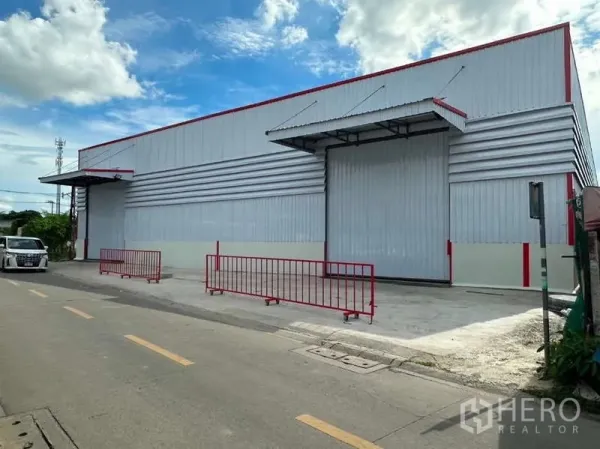 Warehouse for rent in Don Mueang, Bangkok - Street view of a newly built metal-clad warehouse in Don Mueang with covered loading bay and red safety railings.