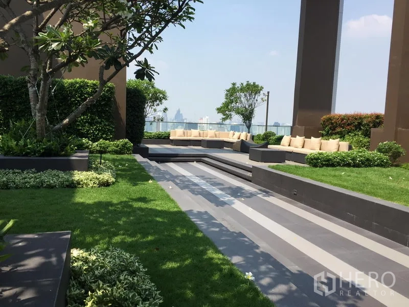 Condominium for rent in Watthana, Bangkok - Landscaped rooftop garden with built‑in seating, trees and open city skyline views.